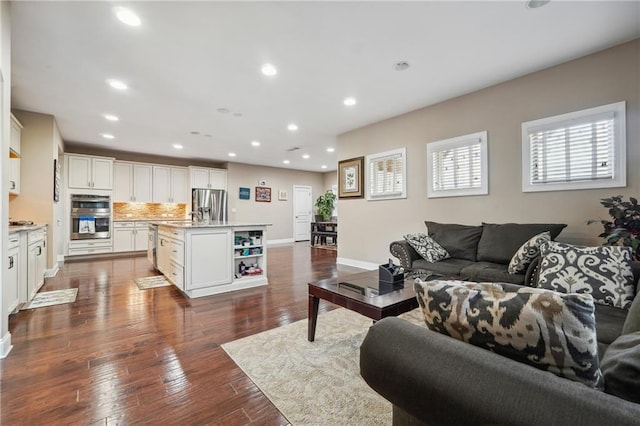 living room with recessed lighting, baseboards, and dark wood-style flooring