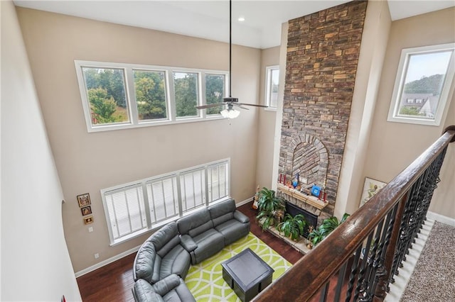 living room with a ceiling fan, wood finished floors, baseboards, recessed lighting, and a fireplace