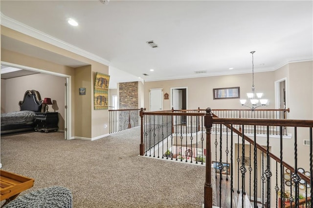 corridor featuring an upstairs landing, a notable chandelier, ornamental molding, and carpet flooring