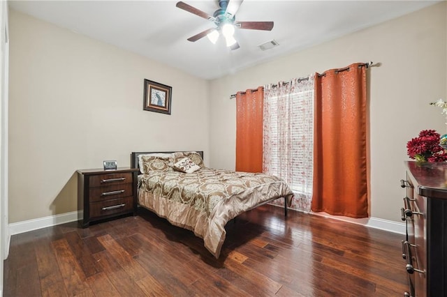 bedroom with dark wood-style floors, visible vents, ceiling fan, and baseboards