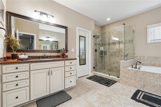 full bathroom with tile patterned flooring, a stall shower, vanity, and a garden tub