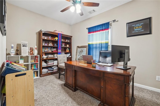 office featuring visible vents, light colored carpet, baseboards, and a ceiling fan