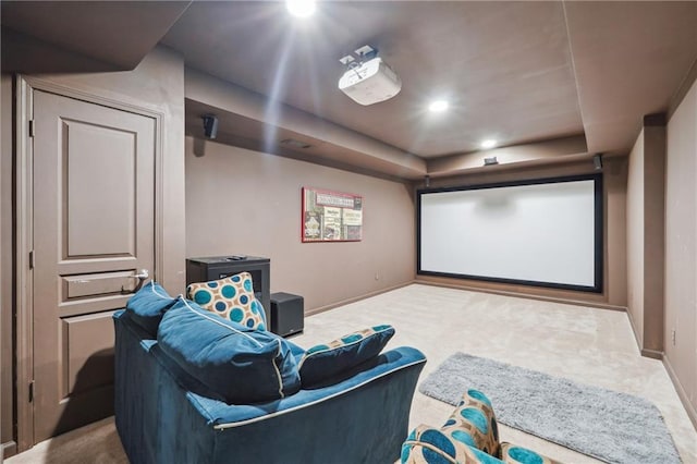 home theater room featuring a tray ceiling, baseboards, and carpet floors