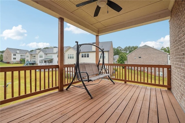 wooden deck with a lawn, a residential view, and ceiling fan