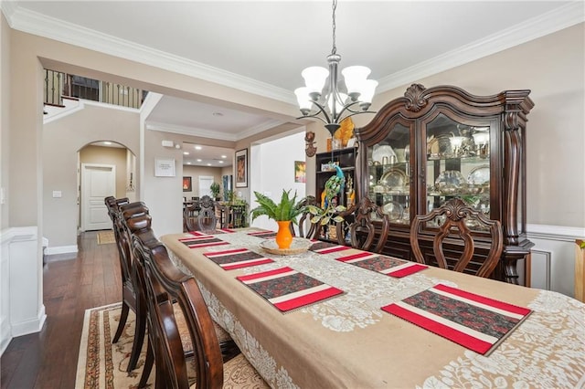 dining area with a chandelier, arched walkways, hardwood / wood-style floors, and crown molding