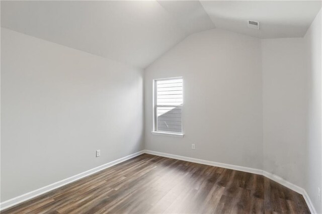empty room with lofted ceiling and dark hardwood / wood-style floors