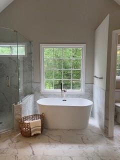 1200 Larson Ln SW, Marietta, GA 30064 - bathroom featuring a marble finish shower, toilet, a freestanding tub, vaulted ceiling, and tile walls