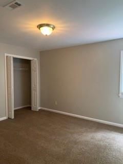 1200 Larson Ln SW, Marietta, GA 30064 - unfurnished bedroom with baseboards, a closet, and dark colored carpet