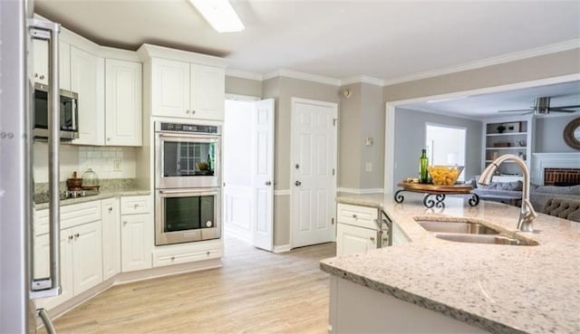 1200 Larson Ln SW, Marietta, GA 30064 - kitchen with appliances with stainless steel finishes, a sink, ornamental molding, white cabinets, and tasteful backsplash