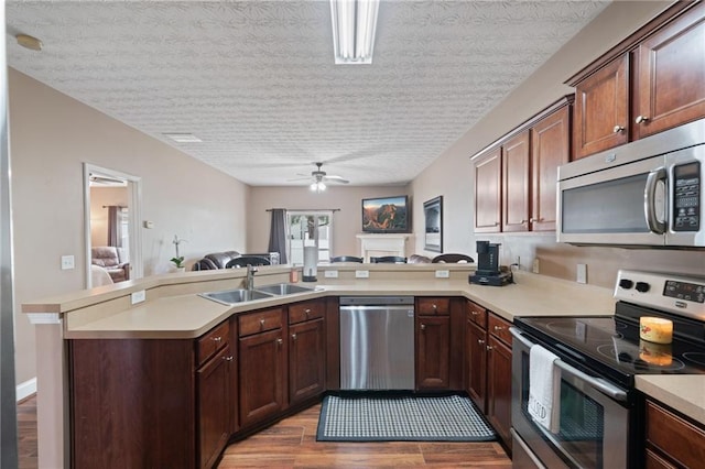 40 Brickton Way E, Dawsonville, GA 30534 - kitchen featuring stainless steel appliances, a peninsula, open floor plan, wood finished floors, and a ceiling fan