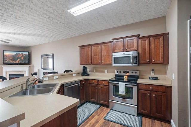 40 Brickton Way E, Dawsonville, GA 30534 - kitchen with stainless steel appliances, a peninsula, light countertops, and light wood-type flooring
