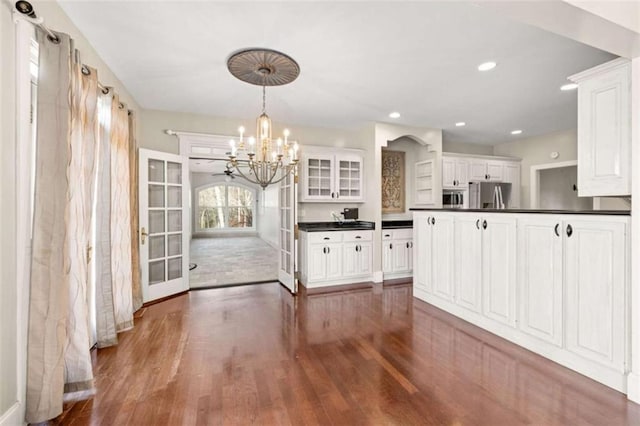 kitchen with white cabinetry, stainless steel appliances, hanging light fixtures, and a chandelier