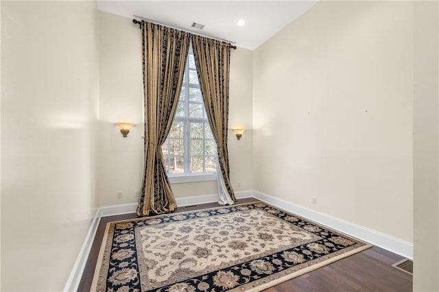 unfurnished room with wood finished floors, baseboards, visible vents, and recessed lighting