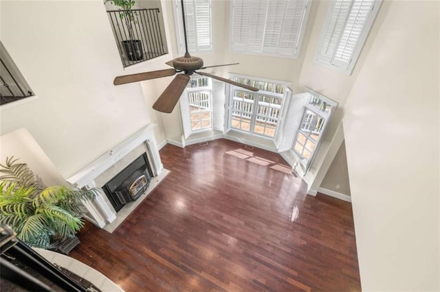 living room featuring dark hardwood / wood-style floors, ceiling fan, and a high ceiling