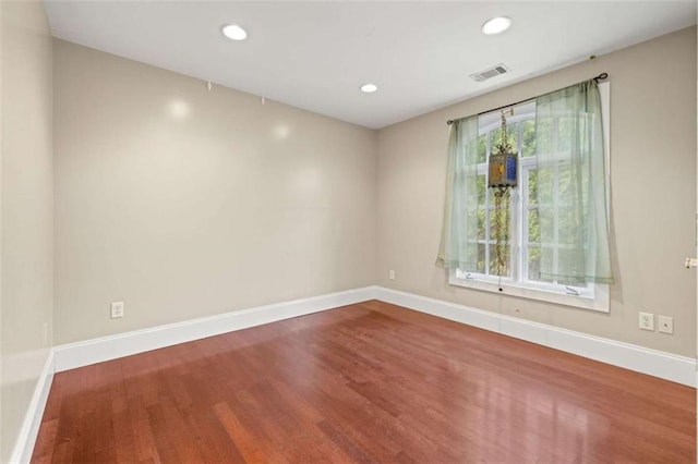 empty room featuring recessed lighting, visible vents, baseboards, and wood finished floors