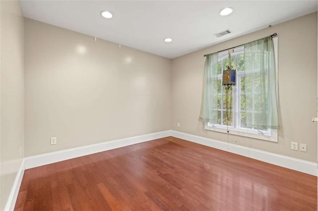 spare room featuring hardwood / wood-style flooring and a healthy amount of sunlight