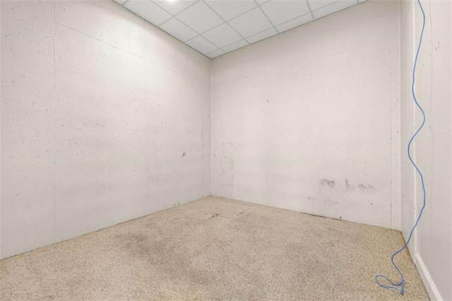 empty room with carpet flooring and a paneled ceiling