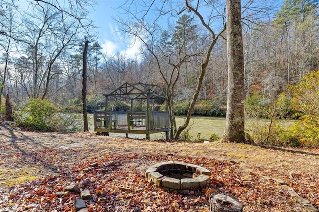 view of yard with a gazebo, a water view, and a fire pit