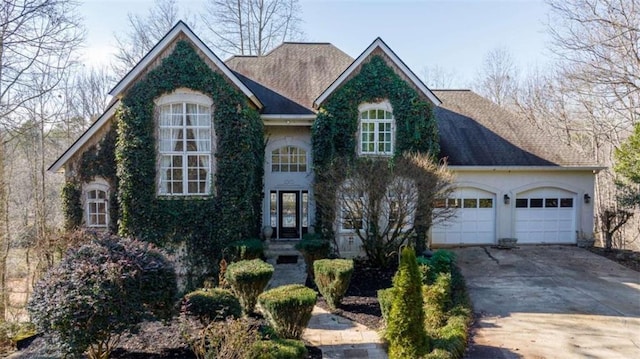 view of front of house with a garage, driveway, and stucco siding