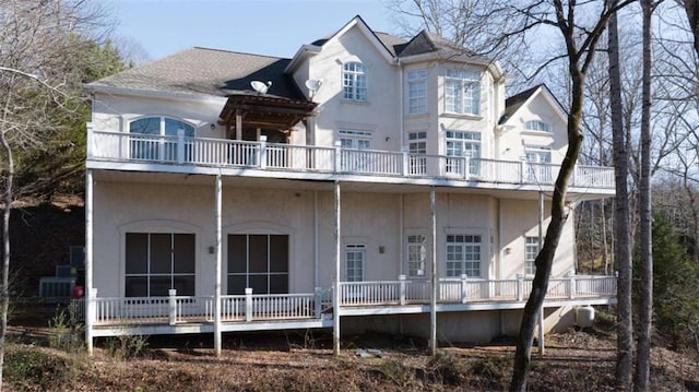 rear view of property featuring a balcony and stucco siding