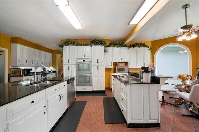 790 Friendship Church Rd, Douglasville, GA 30134 - kitchen featuring appliances with stainless steel finishes, white cabinetry, dark tile patterned flooring, a center island, and a kitchen breakfast bar