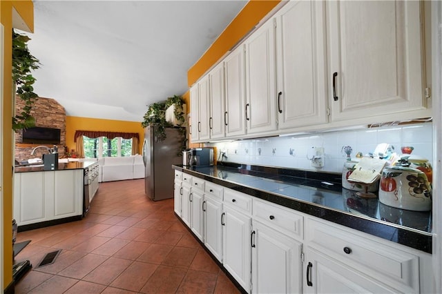 790 Friendship Church Rd, Douglasville, GA 30134 - kitchen featuring white cabinets, tile patterned floors, backsplash, lofted ceiling, and freestanding refrigerator