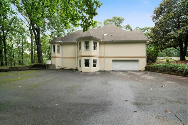 790 Friendship Church Rd, Douglasville, GA 30134 - view of side of home featuring stucco siding, a garage, and asphalt driveway