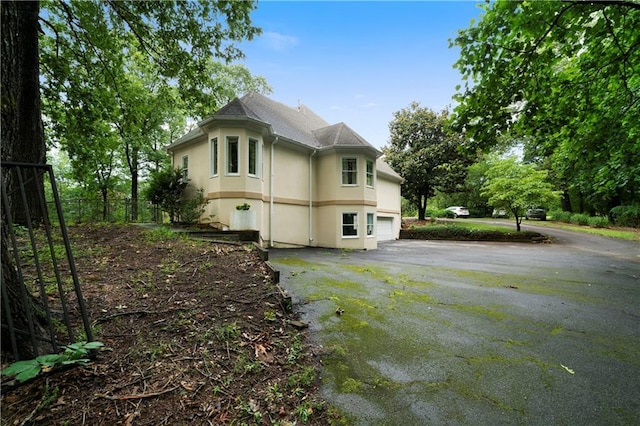 790 Friendship Church Rd, Douglasville, GA 30134 - view of side of home featuring asphalt driveway, an attached garage, and stucco siding