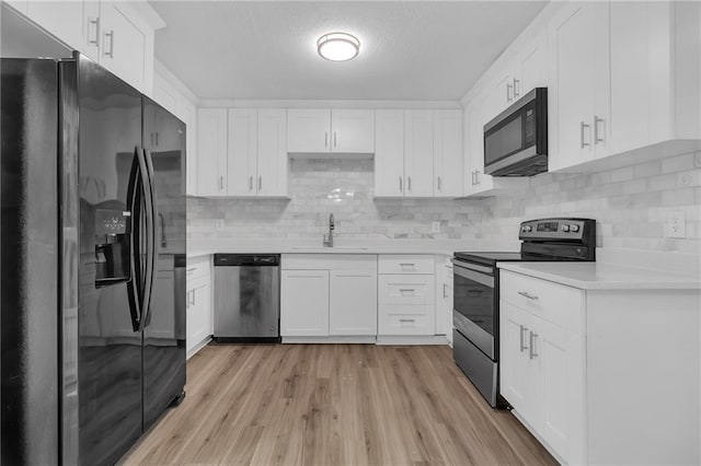 2496 Shiloh Dr, Decatur, GA 30034 - kitchen with appliances with stainless steel finishes, light countertops, tasteful backsplash, light wood-style flooring, and white cabinetry
