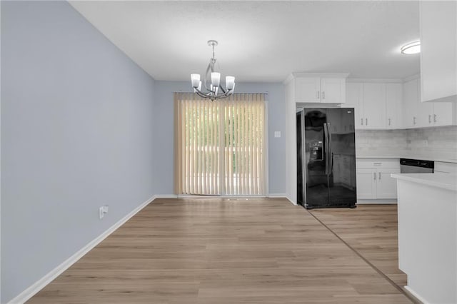 2496 Shiloh Dr, Decatur, GA 30034 - unfurnished dining area with a chandelier, baseboards, and light wood-type flooring
