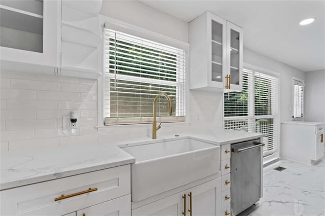 kitchen with stainless steel dishwasher, marble finish floor, white cabinetry, and a sink