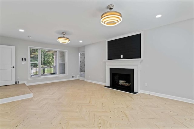 unfurnished living room with visible vents, recessed lighting, a fireplace, and baseboards