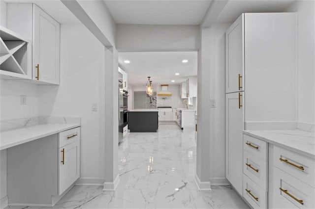 kitchen with white cabinets, recessed lighting, and marble finish floor