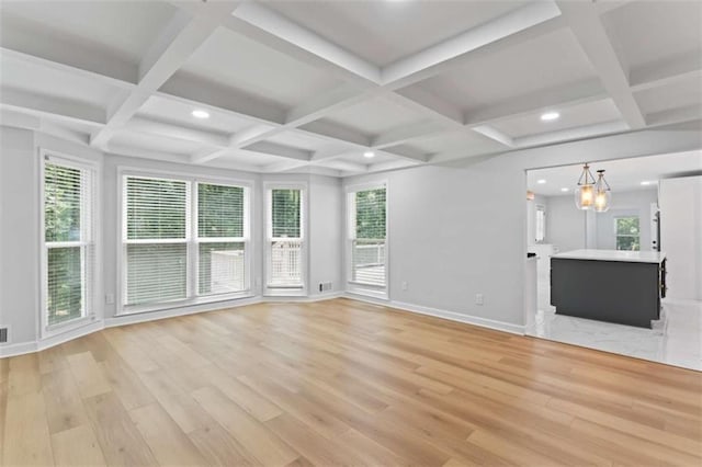 unfurnished living room featuring recessed lighting, baseboards, an inviting chandelier, and light wood finished floors