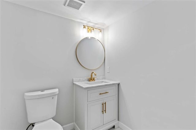 half bath featuring visible vents, baseboards, toilet, and vanity