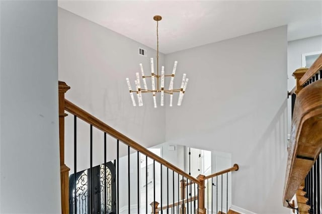 staircase featuring visible vents and a chandelier