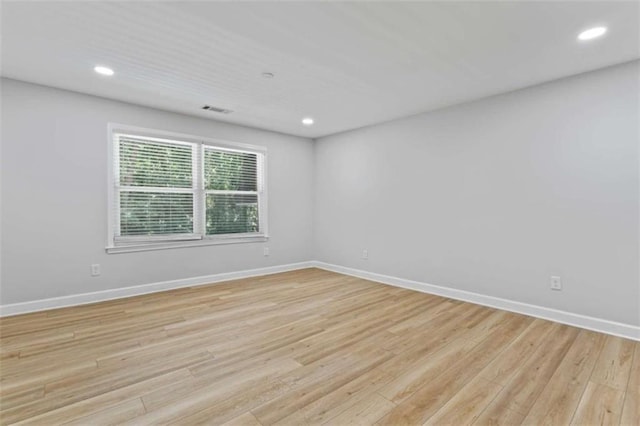 empty room with recessed lighting, light wood-style flooring, and baseboards