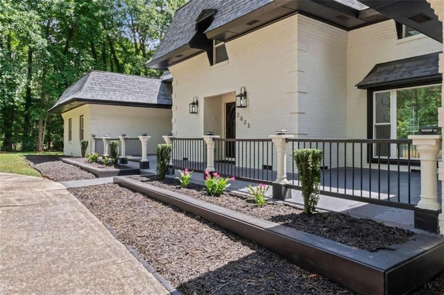 exterior space featuring covered porch and brick siding