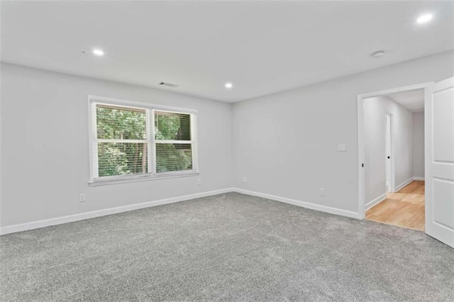 carpeted empty room featuring recessed lighting, visible vents, and baseboards