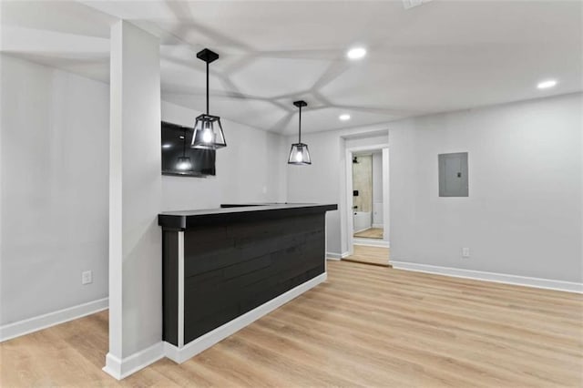 unfurnished living room featuring light wood finished floors, baseboards, electric panel, recessed lighting, and a bar