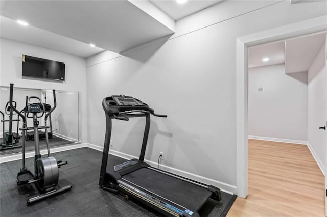 workout room with recessed lighting, baseboards, and wood finished floors