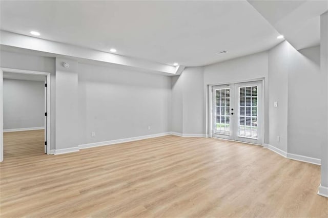 empty room with light wood-style flooring, recessed lighting, french doors, and baseboards