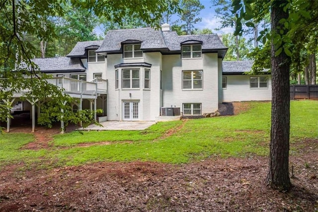 back of property with fence, central AC, french doors, a yard, and a patio area