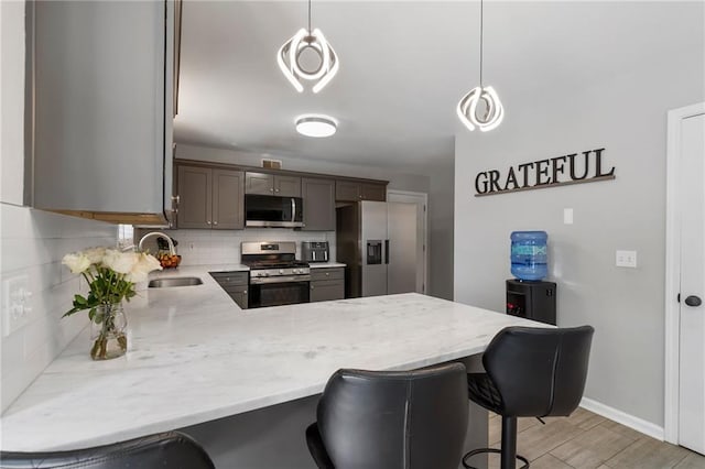 4901 Wilkie Way NW, Acworth, GA 30102 - kitchen with appliances with stainless steel finishes, a peninsula, backsplash, and a breakfast bar