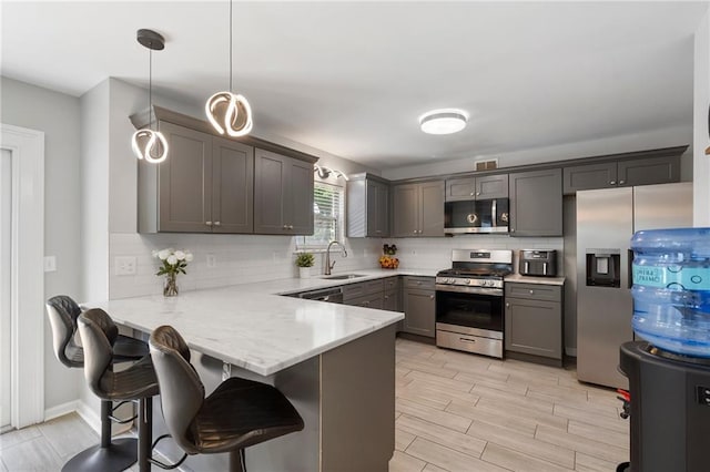 4901 Wilkie Way NW, Acworth, GA 30102 - kitchen featuring stainless steel appliances, a peninsula, backsplash, a kitchen bar, and light stone counters