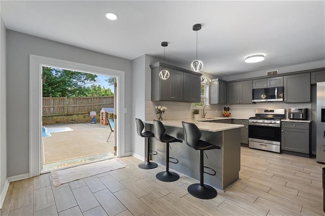4901 Wilkie Way NW, Acworth, GA 30102 - kitchen with appliances with stainless steel finishes, healthy amount of natural light, a peninsula, wood finish floors, and recessed lighting