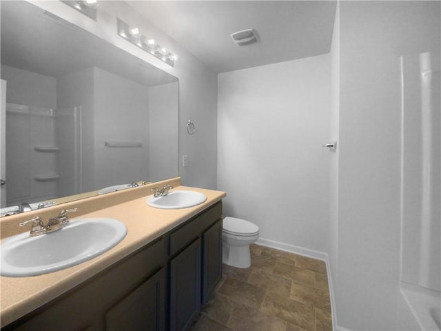 bathroom featuring vanity, walk in shower, and toilet