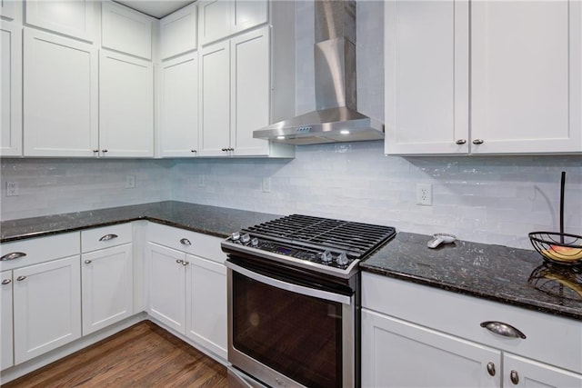 kitchen featuring stainless steel range with gas stovetop, wall chimney range hood, white cabinets, and backsplash