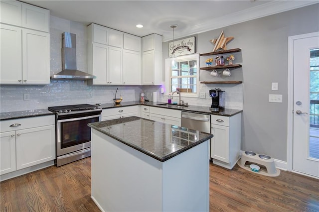 kitchen with wall chimney exhaust hood, stainless steel appliances, a sink, dark wood-style floors, and tasteful backsplash