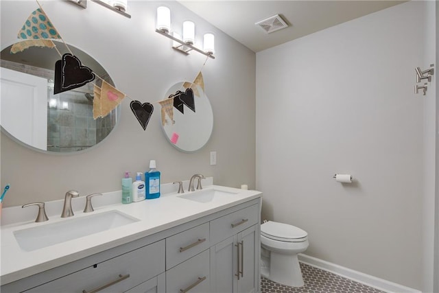 bathroom with toilet, tile patterned floors, double vanity, and baseboards
